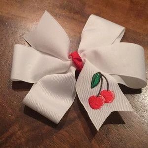 White bow with embroidered cherries.